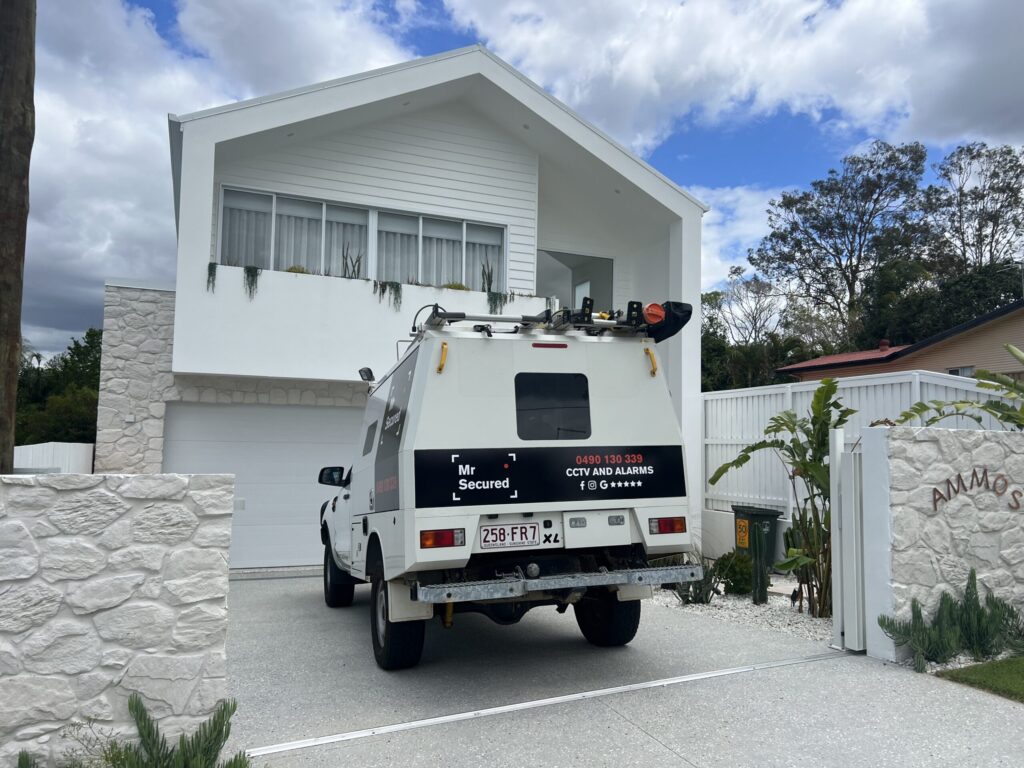 Mr Secured van on site at a modern white double-storey Brisbane home