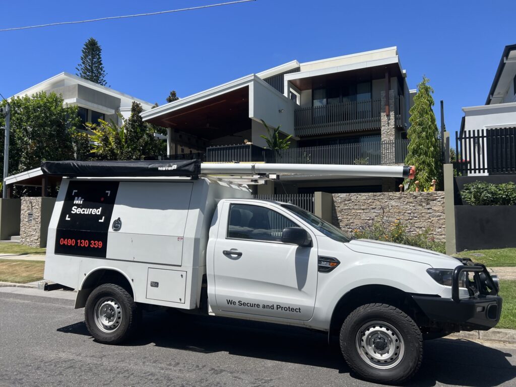 Mr Secured ute at a high-end architectural home with stone fence