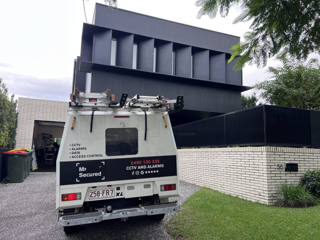 Mr Secured van at a dark modern home with secure fencing