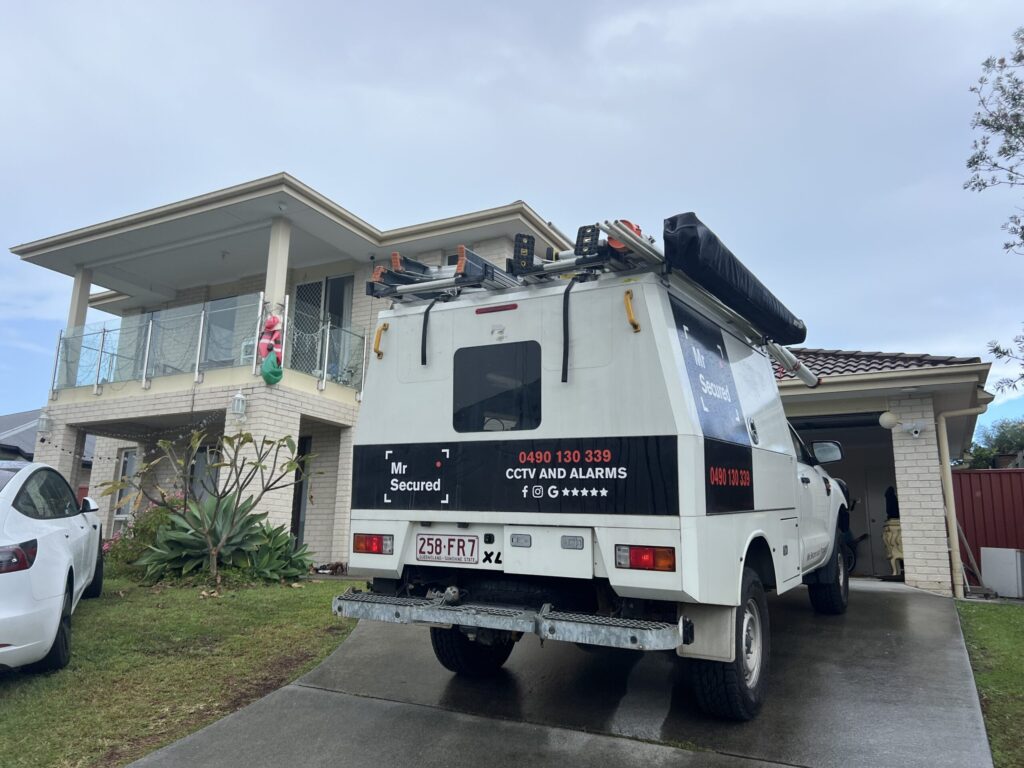 Mr Secured van at a large rendered double-storey home with glass balcony